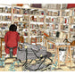 Almudena Grandes is portrayed in her study in Granada, surrounded by bookshelves and personal objects, illustrated print by Ana Jarén