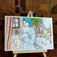 Une femme en peignoir bleu pâle et serviette nouée autour de la tête s’arrête près du lavabo, œuvre originale d’Ana Jarén.