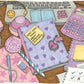 Casque, calculatrice, stylos, carnets, papier quadrillé et accessoires roses couvrent le bureau d’une étudiante autour d’un journal intime.