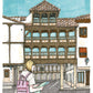 Une voyageuse consulte une carte devant les balcons en bois de la Plaza Mayor de Tembleque, œuvre originale d’Ana Jarén.